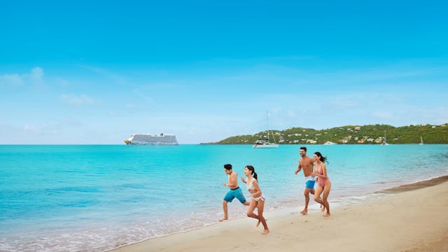 En familj på fyra personer springer på en strand med turkost vatten i bakgrunden. I vattnet kan man se ett Norwegian Cruise Line fartyg. Ta del av en fin flygrabatt till din nästa kryssning.