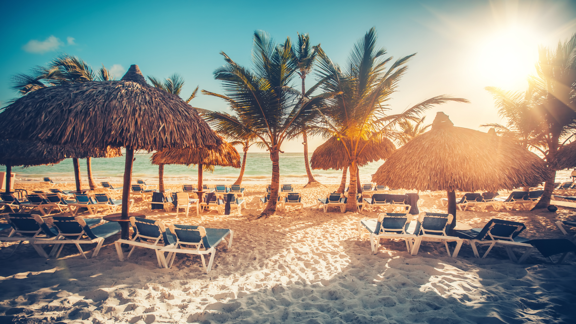 Kryssa i östra Karibien och upplev vackra stränder och kulturella pärlor. Bilden visar en strand med solstolar framför vattnet.