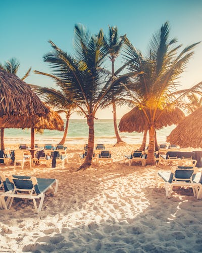 Kryssa i östra Karibien och upplev vackra stränder och kulturella pärlor. Bilden visar en strand med solstolar framför vattnet.