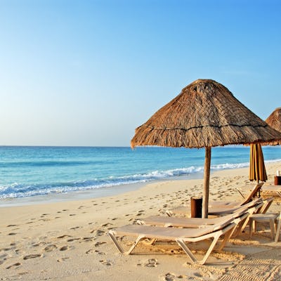 Bilden visar strandstolar vid en strand.
