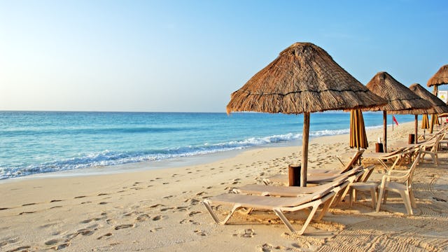 Bilden visar strandstolar vid en strand.