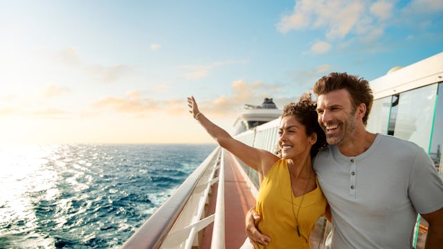 Bild på ett par som står vid räcket på ett fartyg och njuter av utsikten och vinden i håret. Vi hjälper dig välja rätt rederi så du också blir lika nöjd.