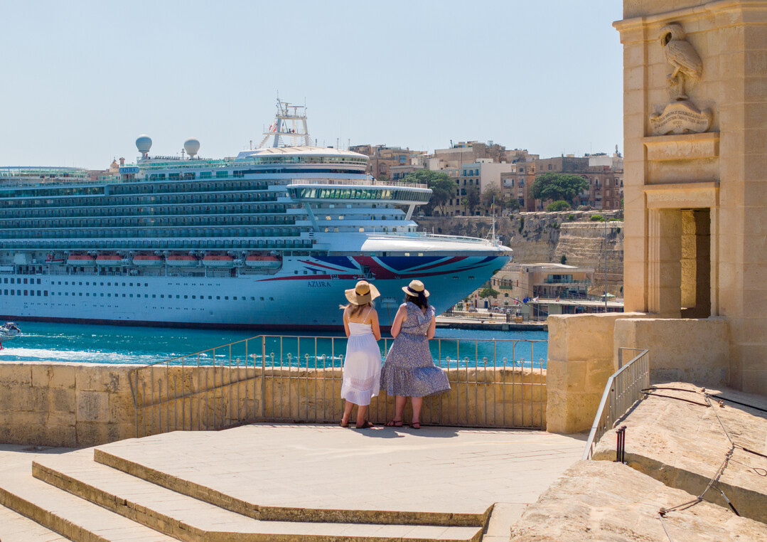 Bilden visar två personer som blickar ut över fartyget Azura från P&Cruises vid en utkiksplats i Malta