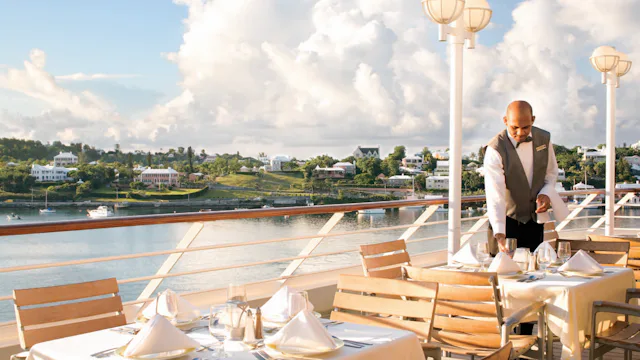 Bilden visar ett dukat bord utomhus ombord på ett Azamara-fartyg