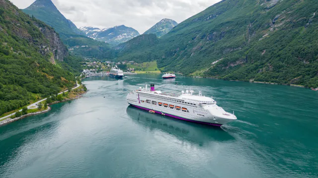 Bilden visar ett fartyg från Ambassador som kryssar i Geiranger