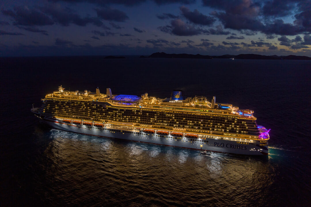 Bilden visar ett upplyst kryssningsfartyg från P&O Cruises under kvällen