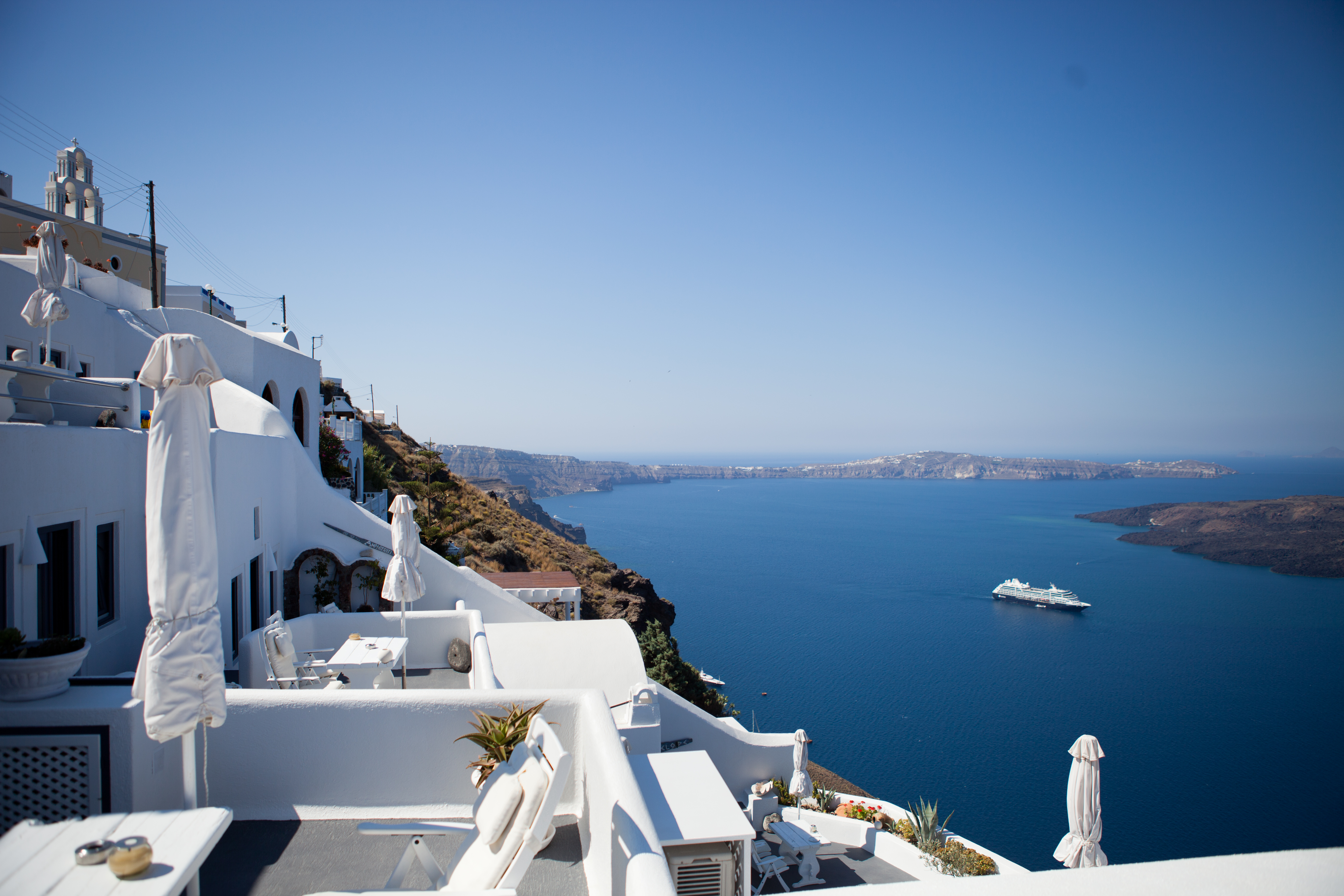 Bilden visar en balkong i Santorini med utsikt över vattnet