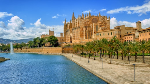 Kryssa runt västra Medelhavet. Bilden visar en katedral vid vatten i Palma de Mallorca i Spanien.