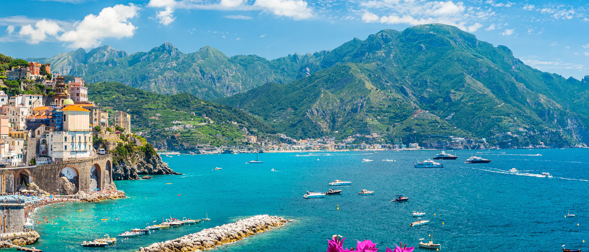 Kryssa runt Medelhavet. Låt en Medelhavskryssning bli din nästa semester fylld av kultur, matglädje och spännande destinationer. Bilden visar Italiens vackra kust med hus, berg och blommor.