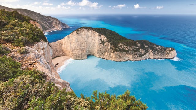 Se Zakynthos vackra klippor på en kryssning runt Grekiska öarna. Bilden visar det turkosa vattnet runt klipporna i Zakynthos.
