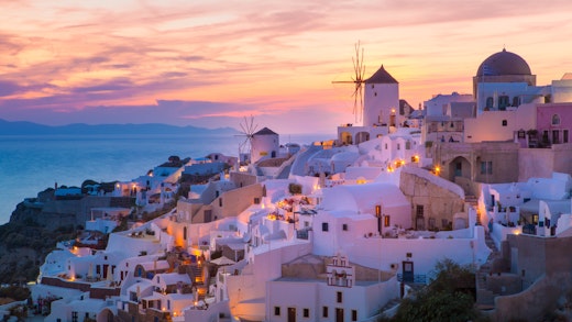 Kryssa runt Grekiska öarna i Medelhavet. Bilden visar en överblivck av Santorinis hus på ett berg i Grekland.