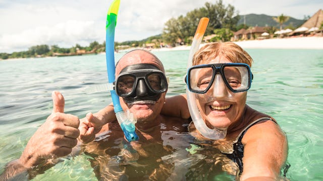 Bilden visar två personer som snorklar i vattnet.