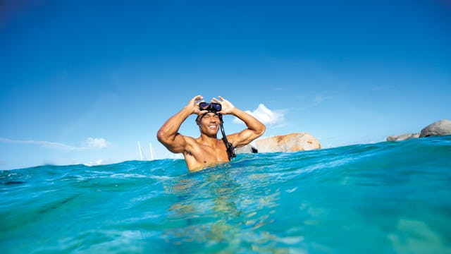 Bilden visar en person i turkost vatten.