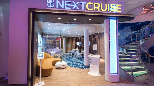 Upplev win-win situation om du blir suga på att boka din nästa kryssning under din kryssning. Bilden visar en översikt på en Next Cruise station ombord Royal Caribbiens fartyg.