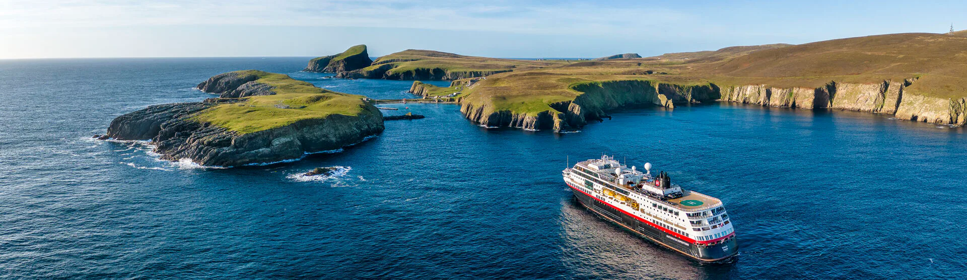 Boka en expeditionskryssning till bästa pris. Här visar vi alla aktuella erbjudanden som HX Hurtigruten Expeditions har. Bilden visar ett av HX fartyg vid Skottlands kust.