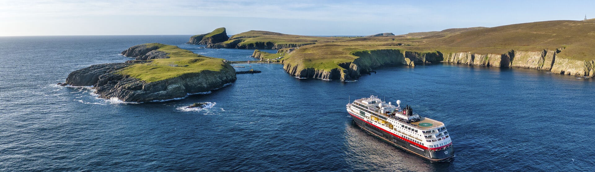 Boka en expeditionskryssning till bästa pris. Här visar vi alla aktuella erbjudanden som HX Hurtigruten Expeditions har. Bilden visar ett av HX fartyg vid Skottlands kust.