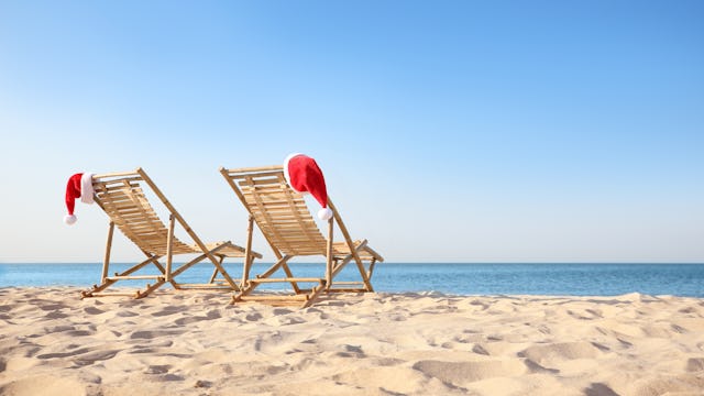 Kryssa med Holland America Line i jul. Bilden visar två solstolar på stranden med två tomtemössor på.