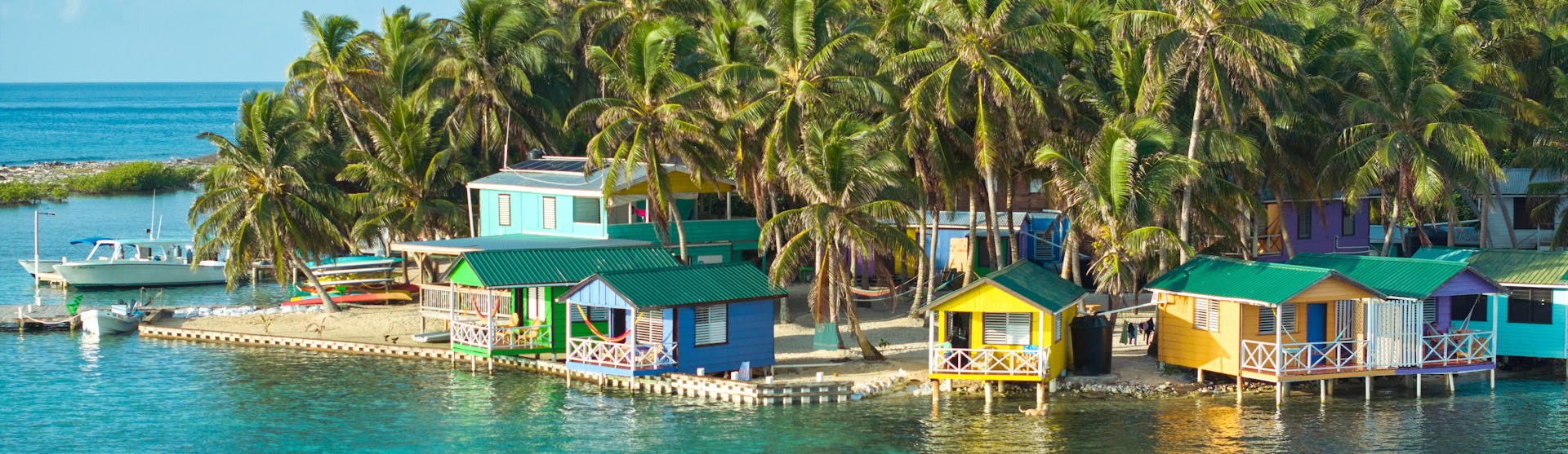 Kryssa i västra Karibien. Bilden visar Belize i Karibien och landets klara vatten där ett par åker på paddel board.