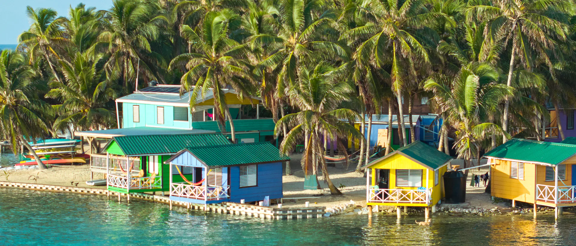 Kryssa i västra Karibien. Bilden visar Belize i Karibien och landets klara vatten där ett par åker på paddel board.