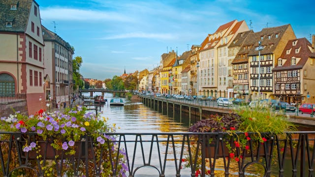 Bilden visar charmiga Strasbourg med floden Rhen som rinner mellan byggnader.