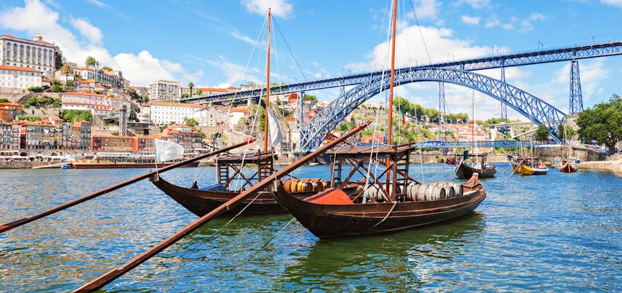 Bilden visar floden Douro med en traditionell båt som ligger i. Upplev en fantastisk portugisisk kultur längs en flodkryssning på Douro.