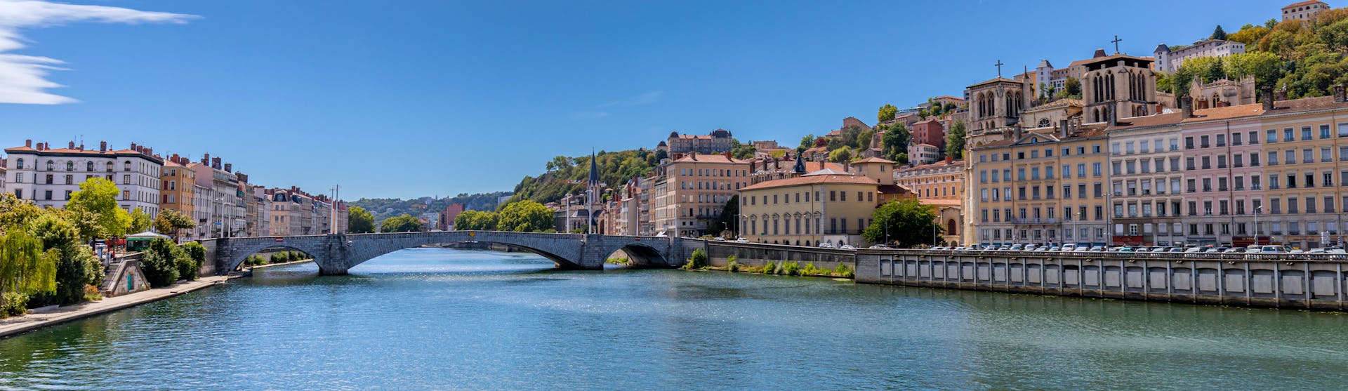 Bilden visar floden Rhone som rinner genom en stad. Boka en mysig flodkryssning längs Rhone och kom nära städer på din resa.