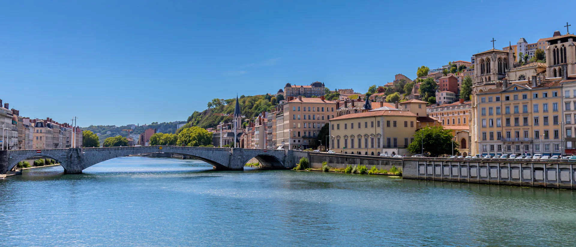 Bilden visar floden Rhone som rinner genom en stad. Boka en mysig flodkryssning längs Rhone och kom nära städer på din resa.