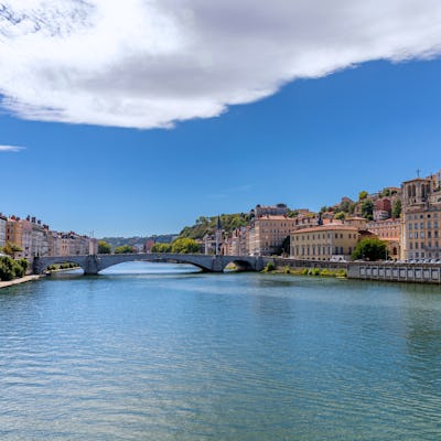 Bilden visar floden Rhone som rinner genom en stad. Boka en mysig flodkryssning längs Rhone och kom nära städer på din resa.