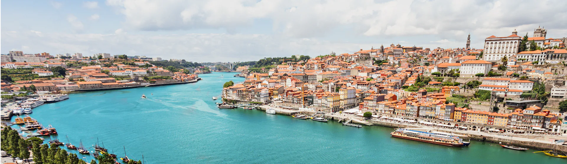 Bilden visar den vackra floden Douro som rinner genom en stad. Upplev en flodkryssning med portugisisk touch längs Douro.