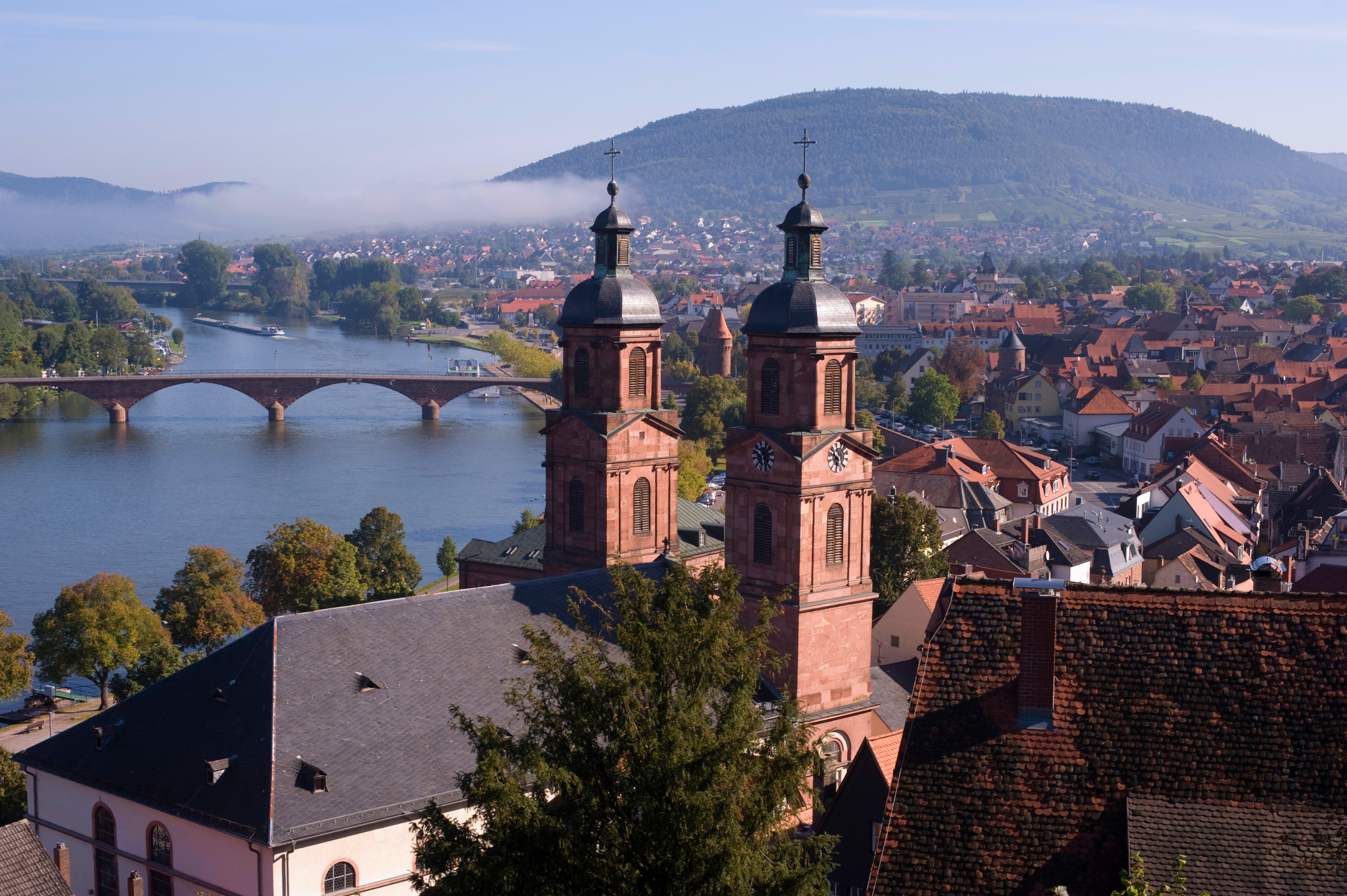Bilden visar staden Miltenberg med kyrkan St. Jakobus i förgrunden och floden Main i bakgrunden.
