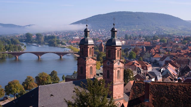 Bilden visar staden Miltenberg med kyrkan St. Jakobus i förgrunden och floden Main i bakgrunden.