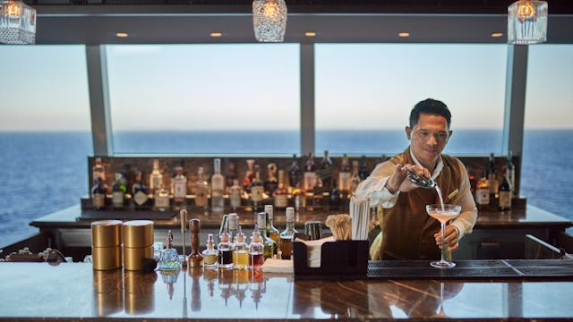Bilden visar en bartender som häller upp en drink ombord Explora.