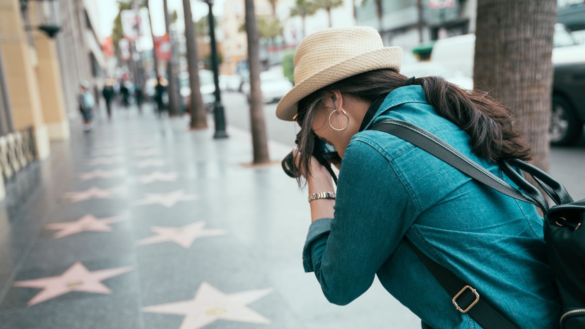 Bilden visar en turist som fotar stjärnorna på trottoaren