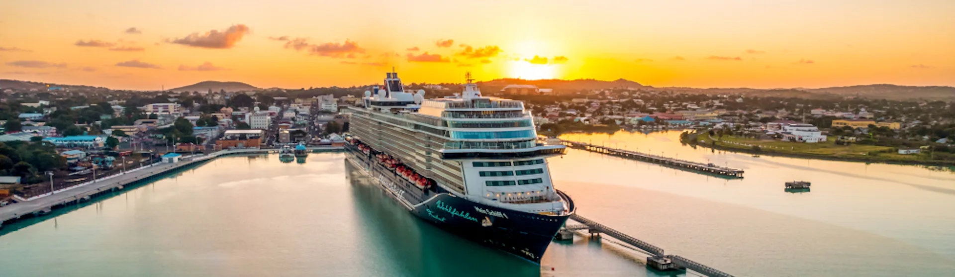 Mein Schiff 1 vid hamn i solnedgång