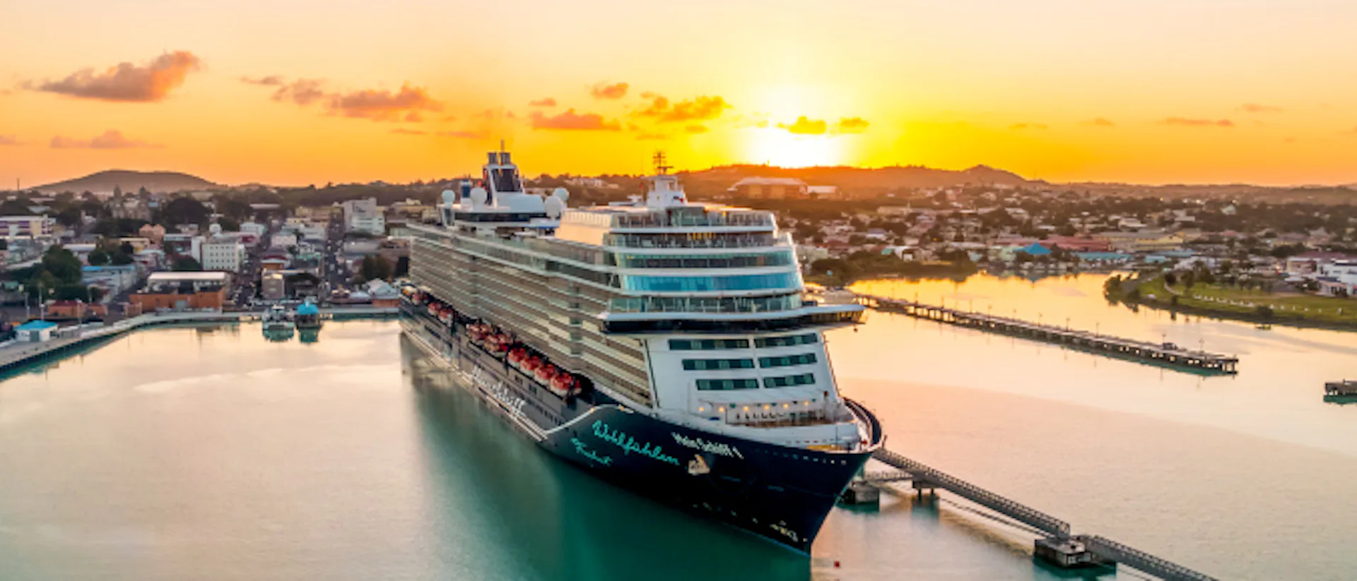 Mein Schiff 1 vid hamn i solnedgång