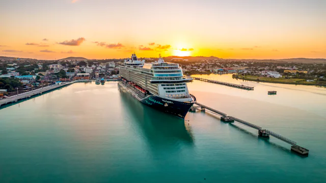 Mein Schiff 1 vid hamn i solnedgång