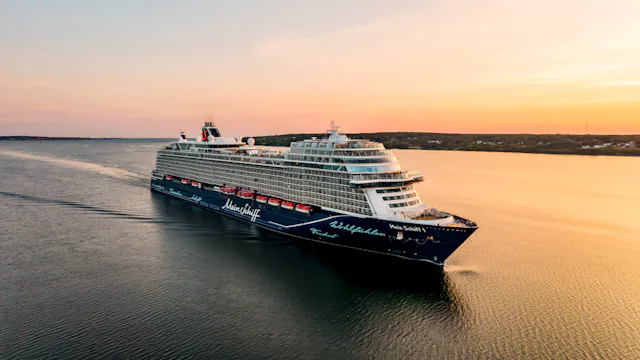 Fartyget Mein Schiff ute på havet i solnedgång