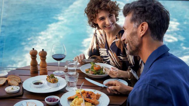Ett par som äter mat utomhus, ombord på Mein Schiff