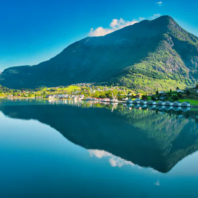 Bild på spegelreflektion av berg i lugnt vatten i Norge