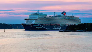 Bilden visar Mein Schiff 7 i hamn i en fantastisk solnedgång.